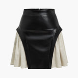 Nerine | Contrasterende kunstleren skaterrok met uitlopende stofinzetten en hoge taille